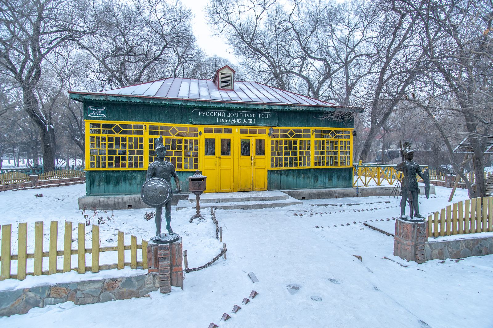 冬雪覆蓋下的俄式小屋，綠牆黃窗，門口有士兵雕像守護