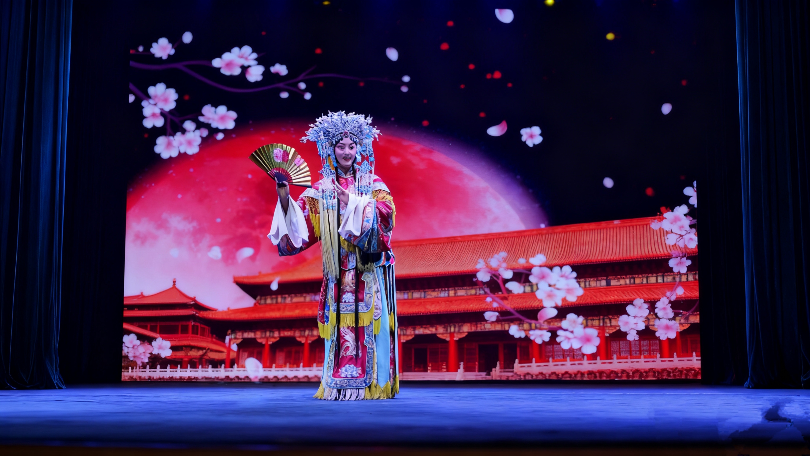 旦角演員在舞臺上表演,飄落的櫻花花瓣為場景增添了浪漫氣息,藍色的舞臺燈光更凸顯出角色的柔美,好似演繹著一段宮廷中的傳奇故事,每一個姿態都充滿了古典韻味 旦角演員在舞臺上表演,飄落的櫻花花瓣為場景增添了浪漫氣息,藍色的舞臺燈光更凸顯出角色的柔美,好似演繹著一段宮廷中的傳奇故事,每一個姿態都充滿了古典韻味