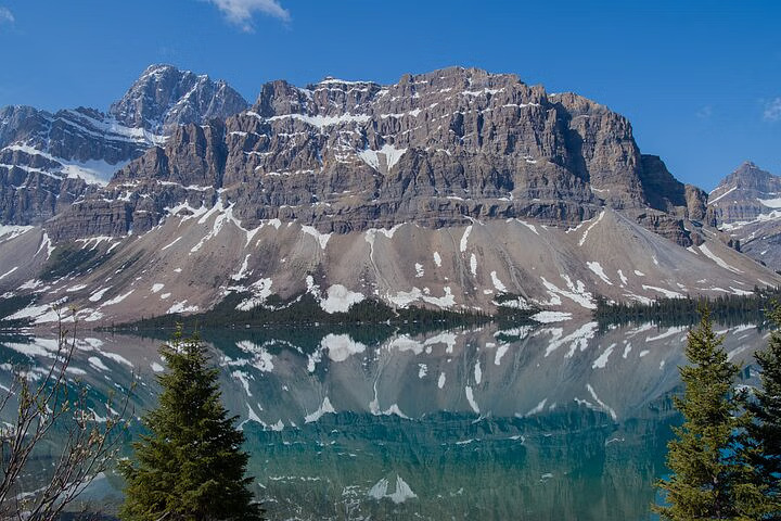 Capture serene Bow River outlet framed by majestic mountains along Icefields Parkway drive