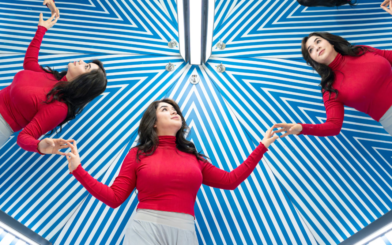 在令人著迷的藍白萬花筒幻象室中，看見自己的倒影無限延伸