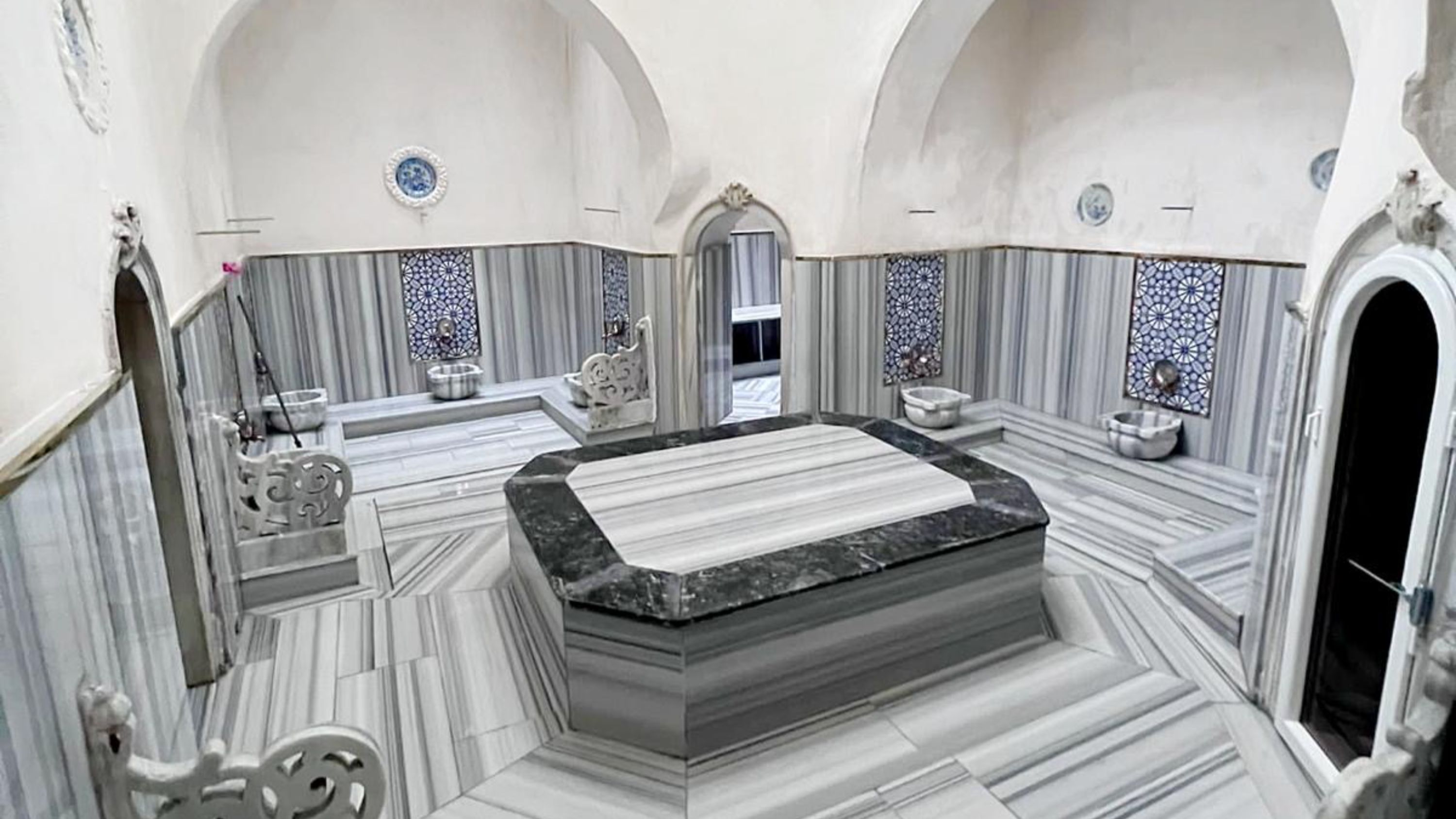 Experience the soothing warmth of marble interiors beneath elegant Ottoman-style domes