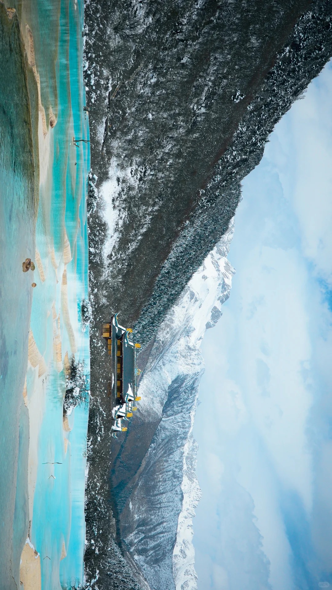 當冬雪輕覆黃龍，澄澈的鈣化池裹著淺藍的柔光，像散落在山谷裡的碎鑽，岸邊的雪絲絨般覆在枯枝與古建簷角