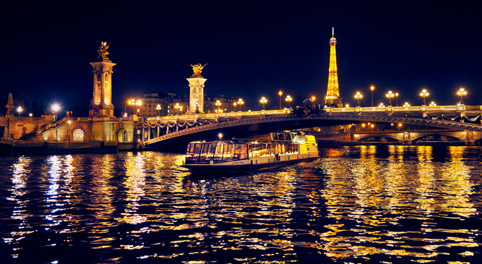 在夜間遊船期間體驗巴黎的魔力，途經燈火通明的亞歷山大三世橋和閃耀的埃菲爾鐵塔。