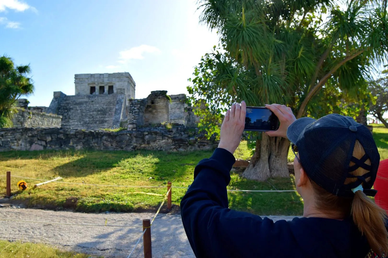 Travelers wading into the cenote, surrounded by vibrant green foliage and tranquility