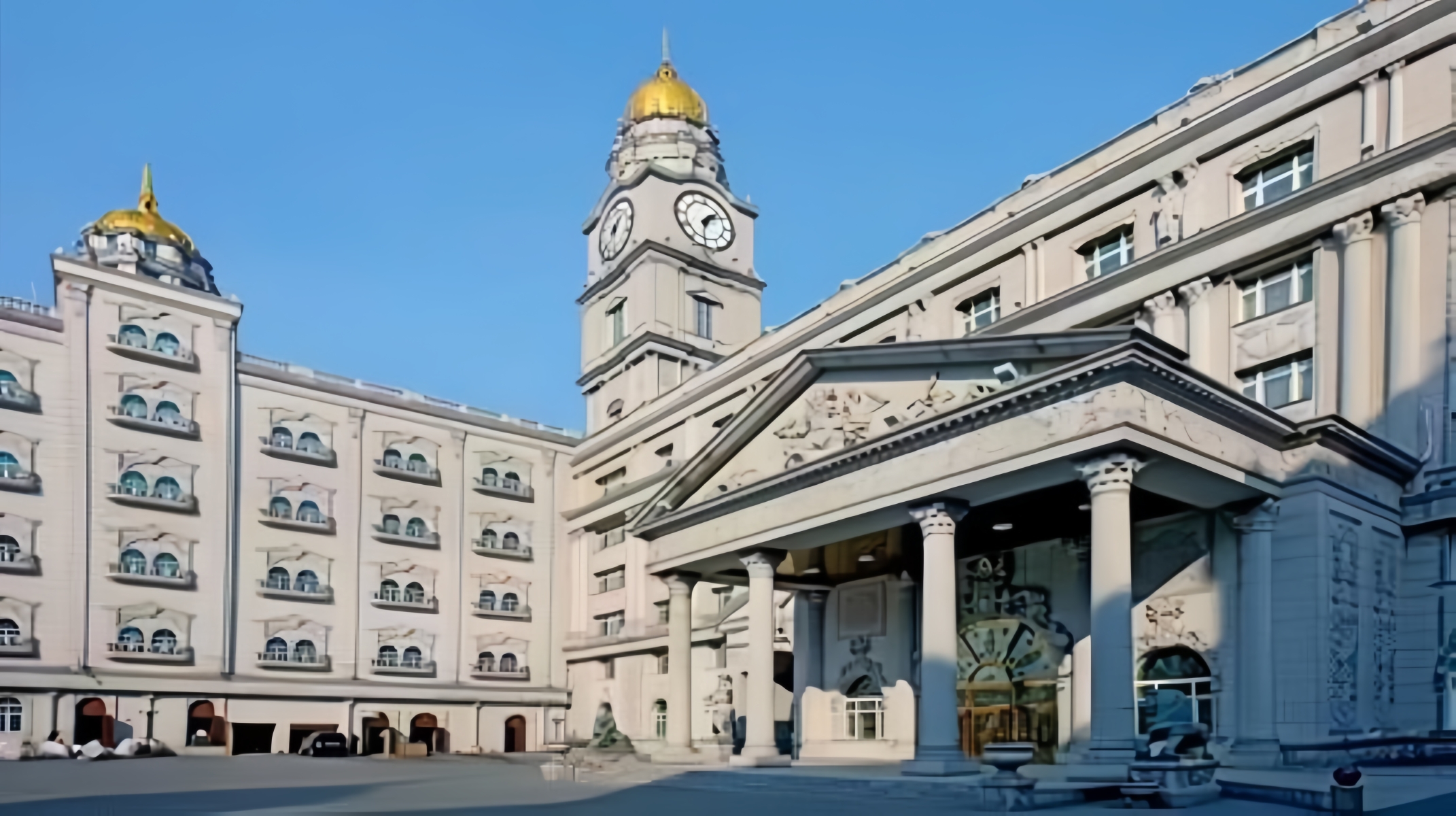 鐘樓與兩側建築相連，整體外立面由淺米色石材構成