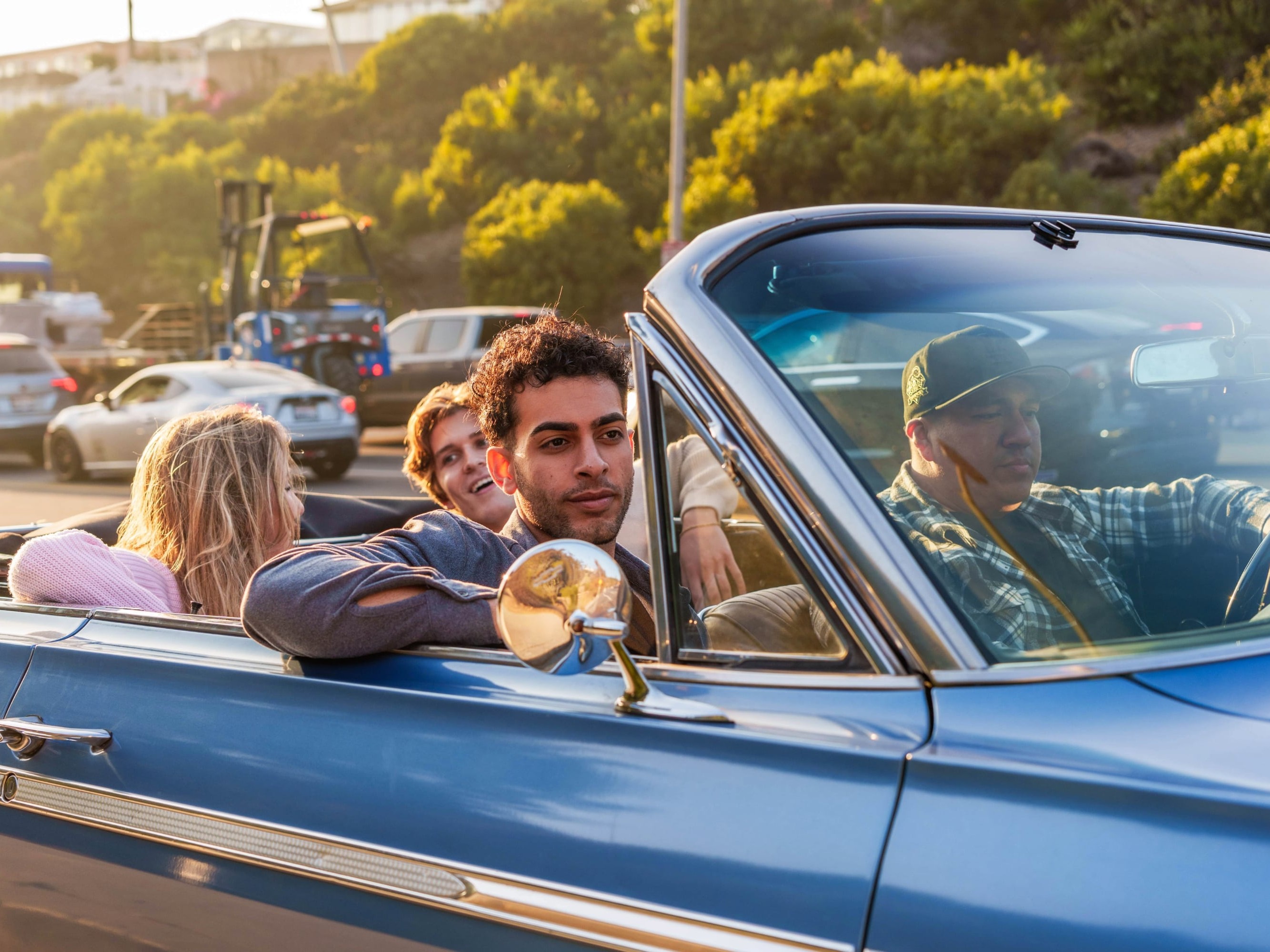 Visitors exploring a historic LA neighborhood with lowriders parked along sidewalks