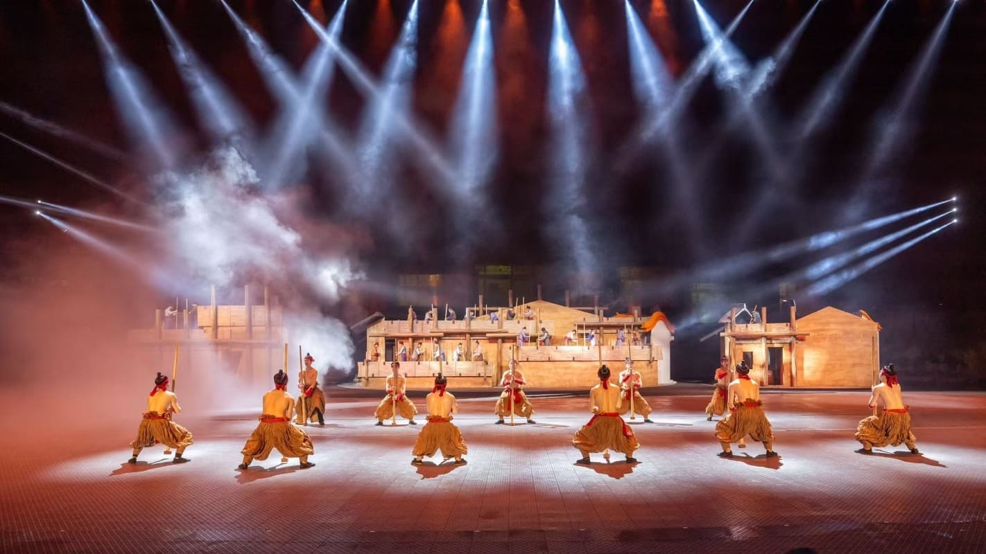 舞臺上英歌隊列整齊,燈光、煙霧營造氛圍,搭配背景建築。借現代舞臺科技,呈現英歌表演的磅礴氣勢,演繹潮汕歷史片段,讓觀眾沉浸式感受英歌舞的震撼與文化底蘊 舞臺上英歌隊列整齊,燈光、煙霧營造氛圍,搭配背景建築。借現代舞臺科技,呈現英歌表演的磅礴氣勢,演繹潮汕歷史片段,讓觀眾沉浸式感受英歌舞的震撼與文化底蘊