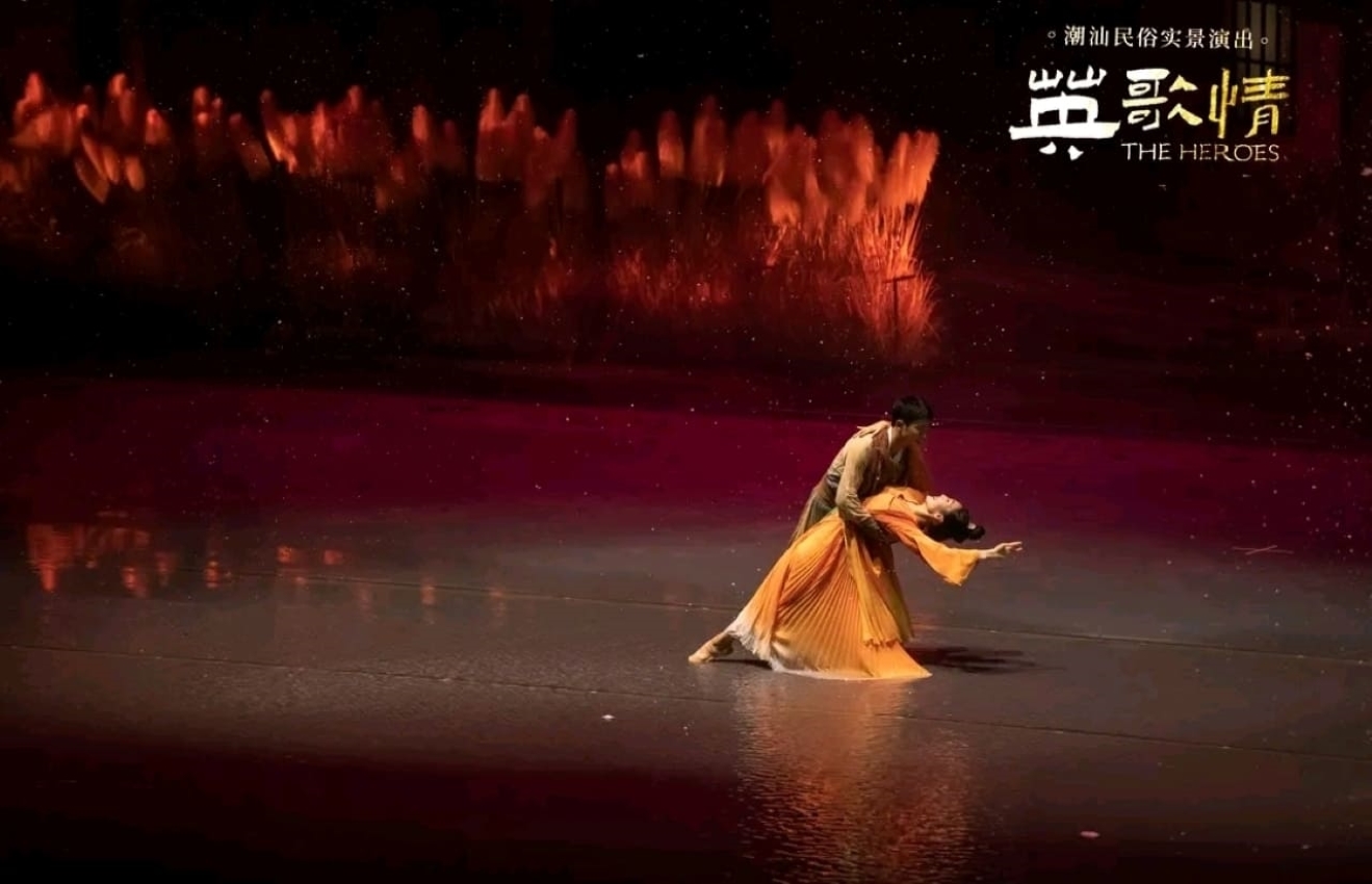 男女舞者以優美舞姿,在光影流轉的舞臺呈現情感張力。暖色調服飾與背景蘆葦相襯,動作纏綿卻不失力量,傳遞潮汕故事中愛情與命運的交織,展現民俗文化的敘事魅力 男女舞者以優美舞姿,在光影流轉的舞臺呈現情感張力。暖色調服飾與背景蘆葦相襯,動作纏綿卻不失力量,傳遞潮汕故事中愛情與命運的交織,展現民俗文化的敘事魅力