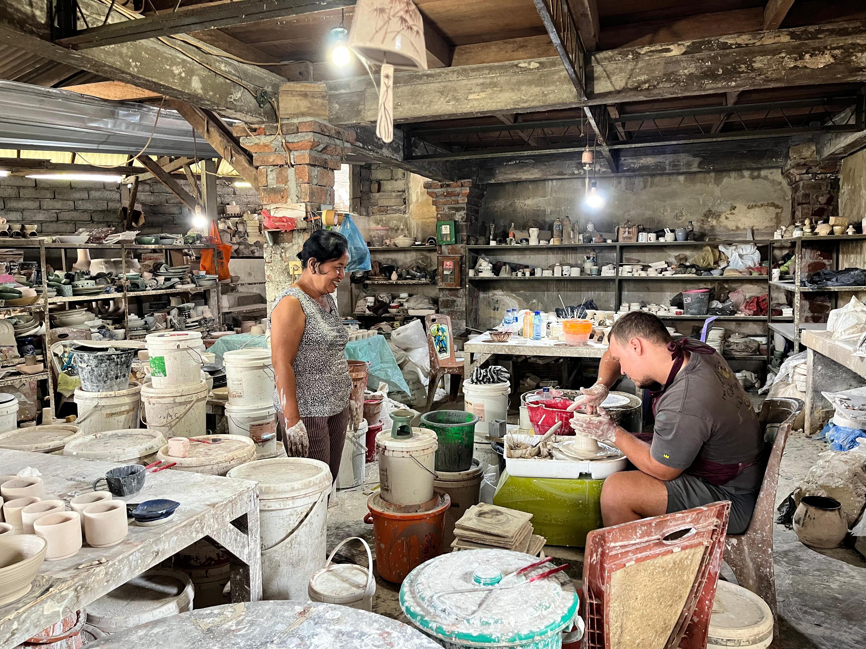 Workshop atmosphere: participants learning pottery hands-on with guidance from the instructor.