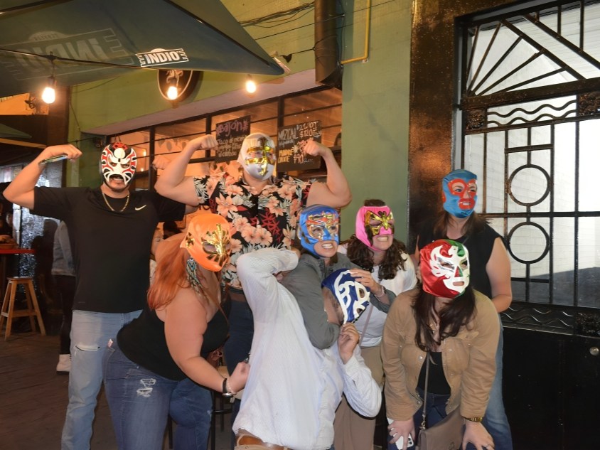 興奮的人群與摔跤手合影，在競技場入口外拍照和大笑