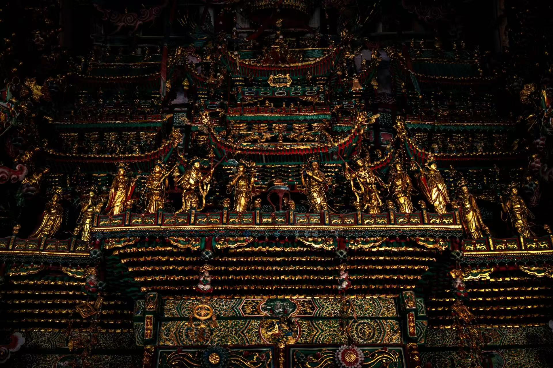 小西天上層懸塑細節精巧，一排鎏金仙佛整齊佇立，樓閣層疊錯落，綠紅彩漆搭配鎏金紋飾繁複華麗，萬千小型造像佈滿樓閣縫隙，雕刻細膩繁複，極具視覺衝擊力