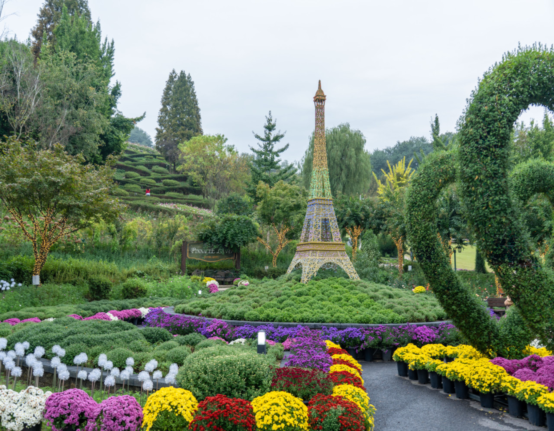 「這是巴黎嗎？」花園中央矗立著艾菲爾鐵塔雕塑！在秋日花園中，捕捉紫黃相間的菊花，盡情享受異國情調的氛圍。