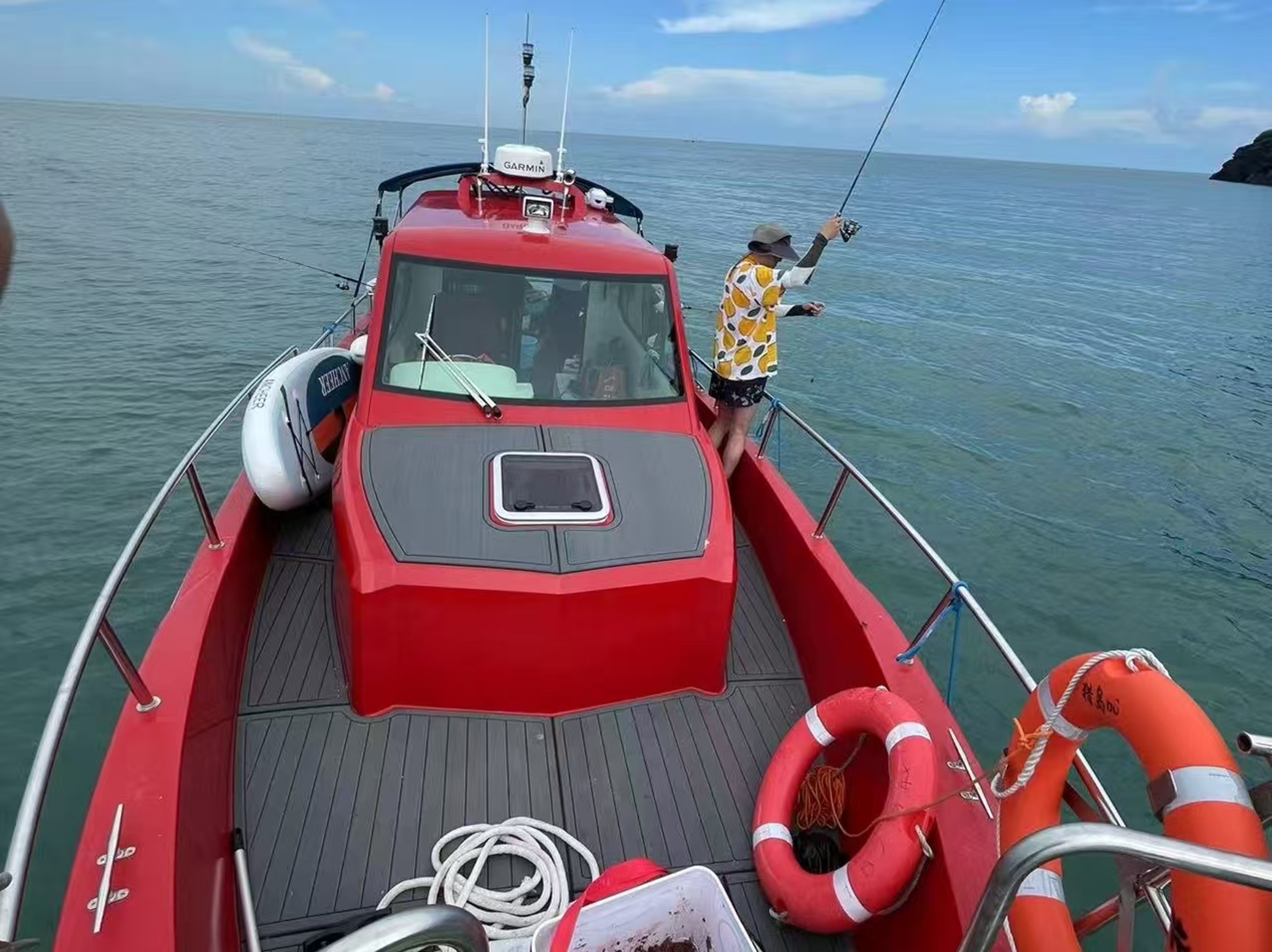 船身配備救生圈、漁具,遊客戴帽持竿專注垂釣,遠處島嶼隱約可見,藍天碧海襯得船身鮮亮,滿是海釣的鬆弛與期待 船身配備救生圈、漁具,遊客戴帽持竿專注垂釣,遠處島嶼隱約可見,藍天碧海襯得船身鮮亮,滿是海釣的鬆弛與期待