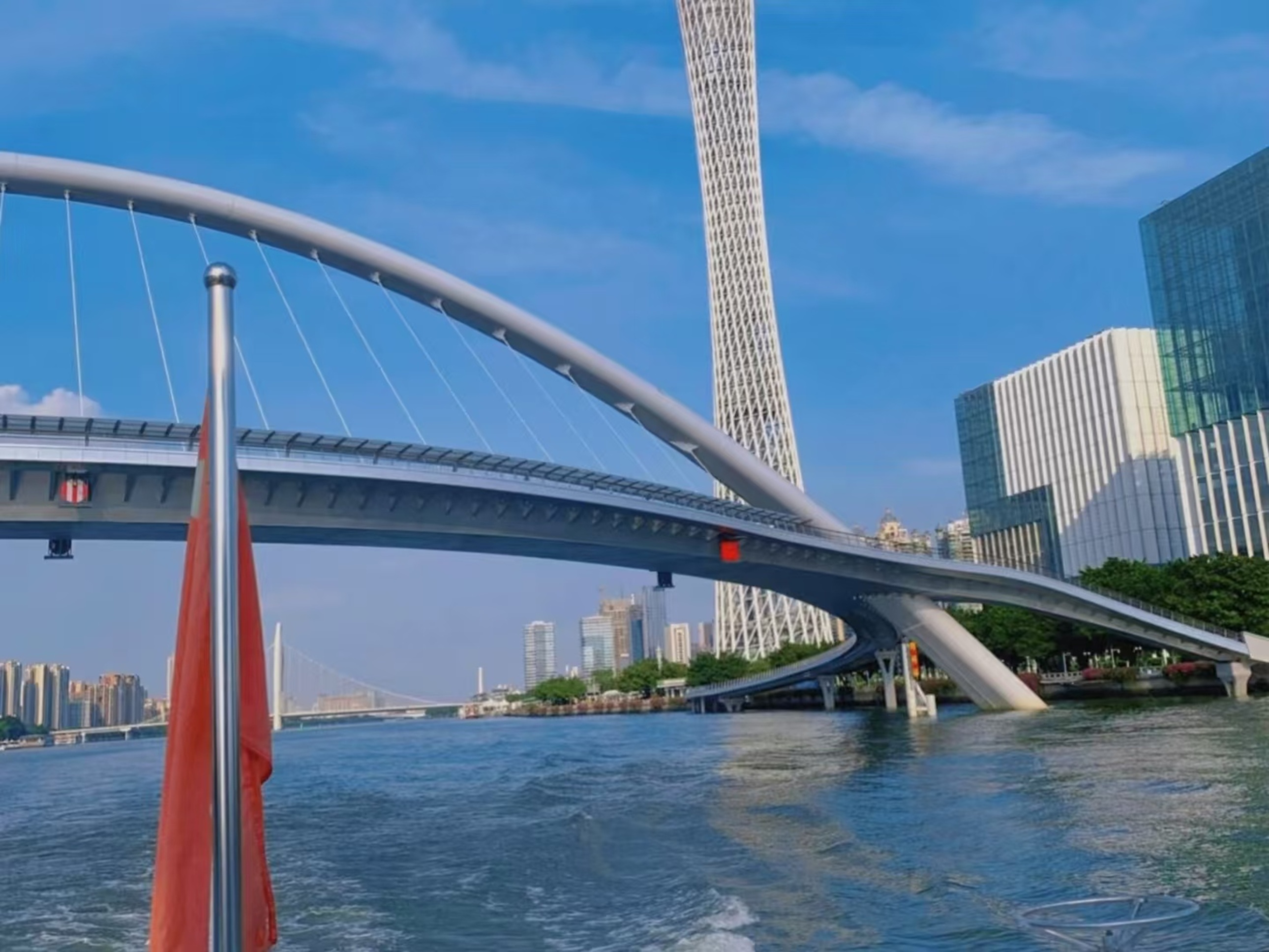 白日裡的海心橋與廣州塔同框,橋身銀白弧線輕盈舒展,珠江水面泛著波紋,岸邊建築與遠處橋樑錯落,晴朗藍天襯得城市風貌清新開闊 白日裡的海心橋與廣州塔同框,橋身銀白弧線輕盈舒展,珠江水面泛著波紋,岸邊建築與遠處橋樑錯落,晴朗藍天襯得城市風貌清新開闊
