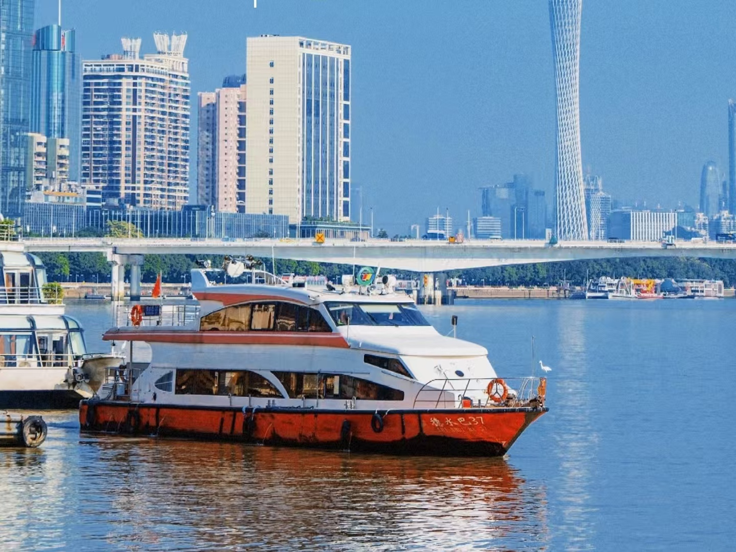 主題遊船滿載遊客遊弋江面,船身霓虹與亞運場館的紅橙燈光呼應,對岸摩天樓群燈火璀璨,江水折射出斑斕光影,盡顯夜航繁華 主題遊船滿載遊客遊弋江面,船身霓虹與亞運場館的紅橙燈光呼應,對岸摩天樓群燈火璀璨,江水折射出斑斕光影,盡顯夜航繁華