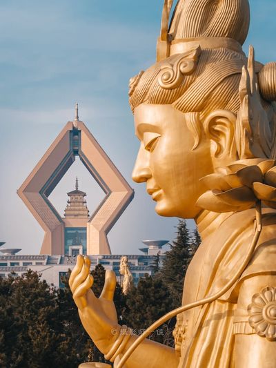 陝西寶雞法門寺文化景區內，巨大的金色觀音造像側影與標誌性的合十舍利塔同框，盡顯佛教聖地的莊嚴與震撼