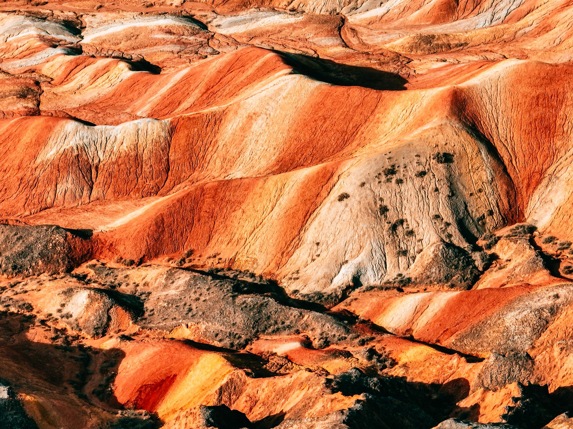 國家 5A 級景區、世界地質公園，國內唯一丹霞與彩色丘陵高度複合的地貌；億萬年沉積 + 風化，紅橙黃綠青灰層理分明，隨日光、晨昏、陰晴變幻出流動的油畫質感