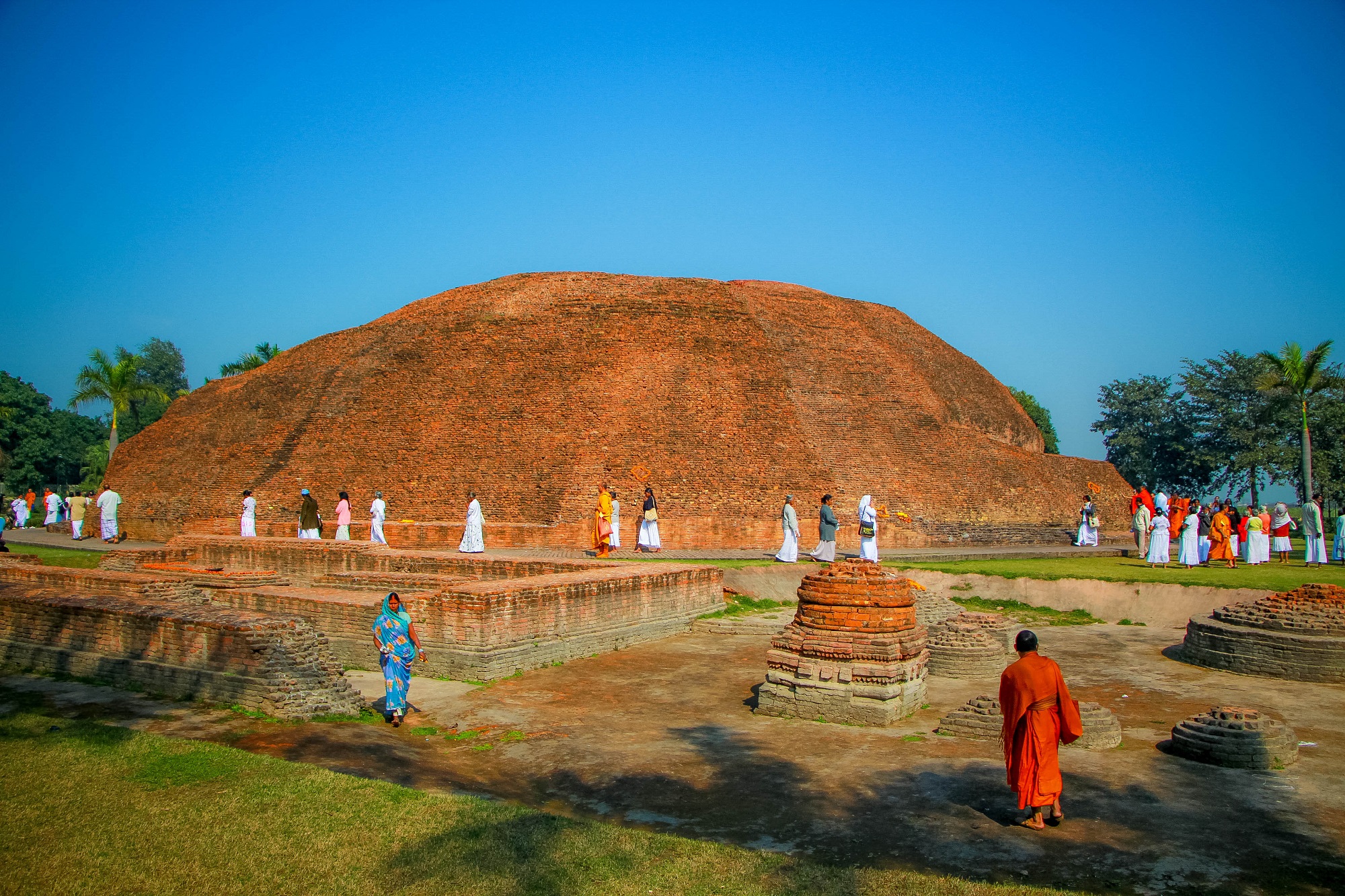 Buddhist monk stands in front of The Ramabhar Stupa to worship The Buddha_s cremation place in Kushinagar.