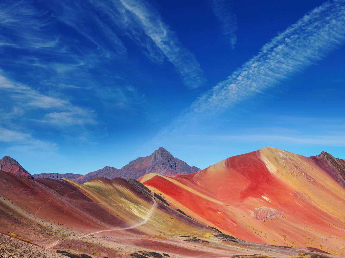Admire the vibrant stripes of Rainbow Mountain formed by natural mineral deposits