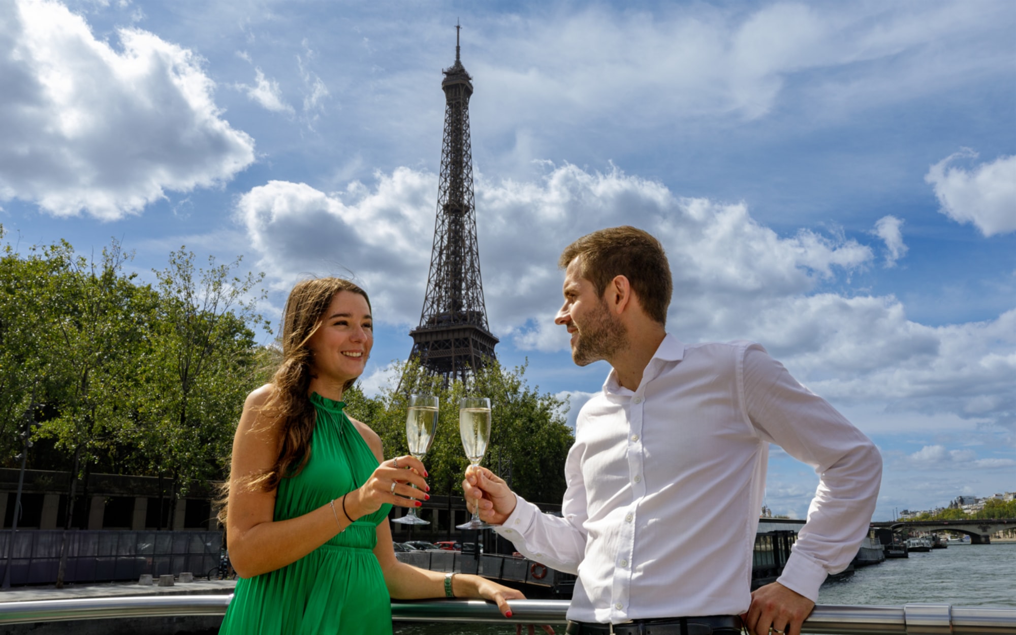 一對情侶在巴黎塞納河遊船的甲板上享用飲品,背景是高聳的艾菲爾鐵塔,在沿河航行時營造出輕鬆愜意的風景時刻。 一對情侶在巴黎塞納河遊船的甲板上享用飲品,背景是高聳的艾菲爾鐵塔,在沿河航行時營造出輕鬆愜意的風景時刻。