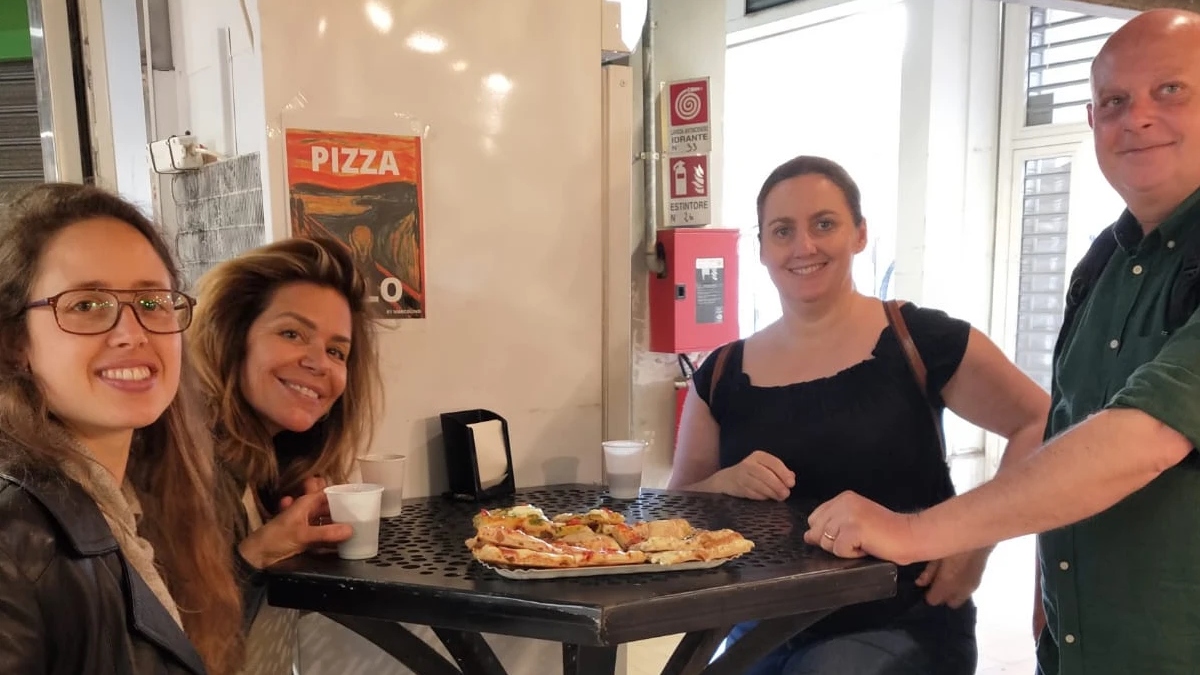 Tour participants enjoy authentic Roman pizza during the Trionfale food market tour