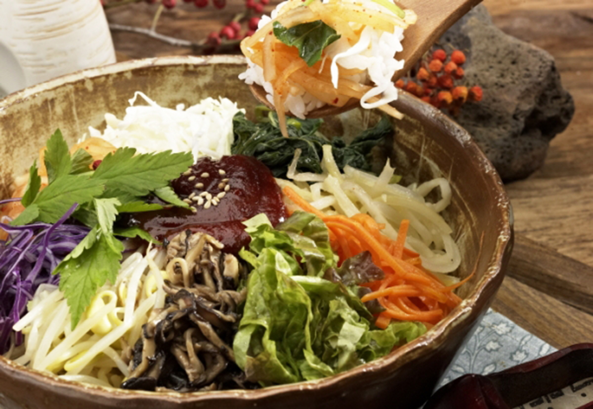 這道韓式拌飯以各式新鮮蔬菜精心擺盤，完美呈現傳統韓式料理的和諧風味。