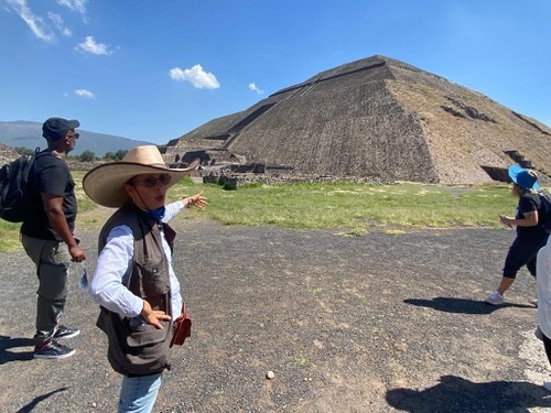 Local guide explaining Teotihuacan's history to captivated tourists in English