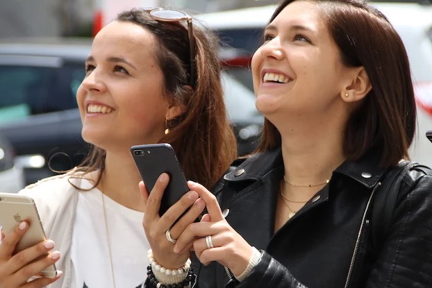 Two females exploring using their smartphones