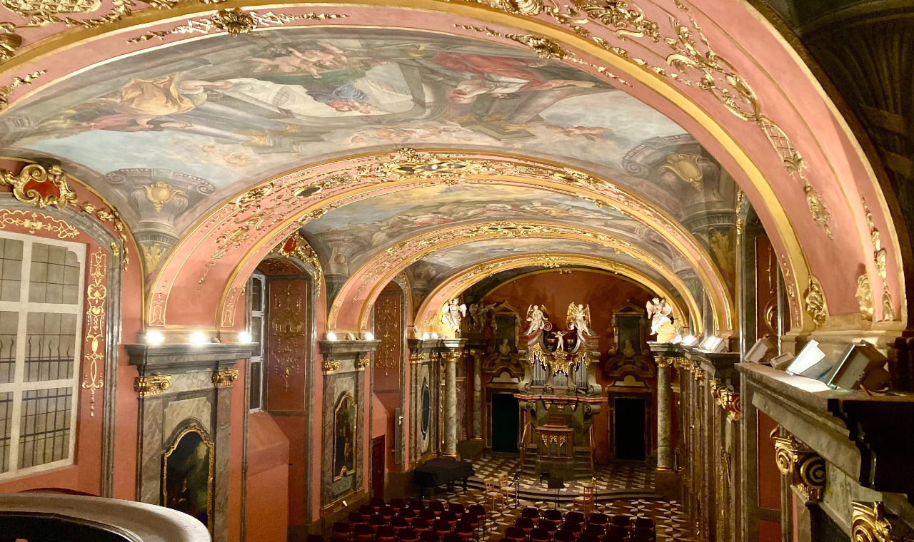 Grand hall featuring a beautifully frescoed ceiling, detailed artwork, and dramatic architectural design