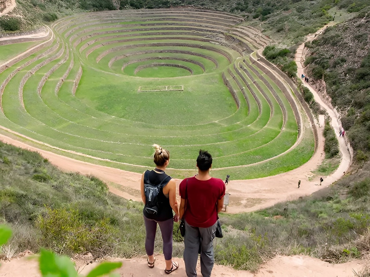 Close-up shot of Moray’s circular terraces framed by vibrant green grass and sunlight