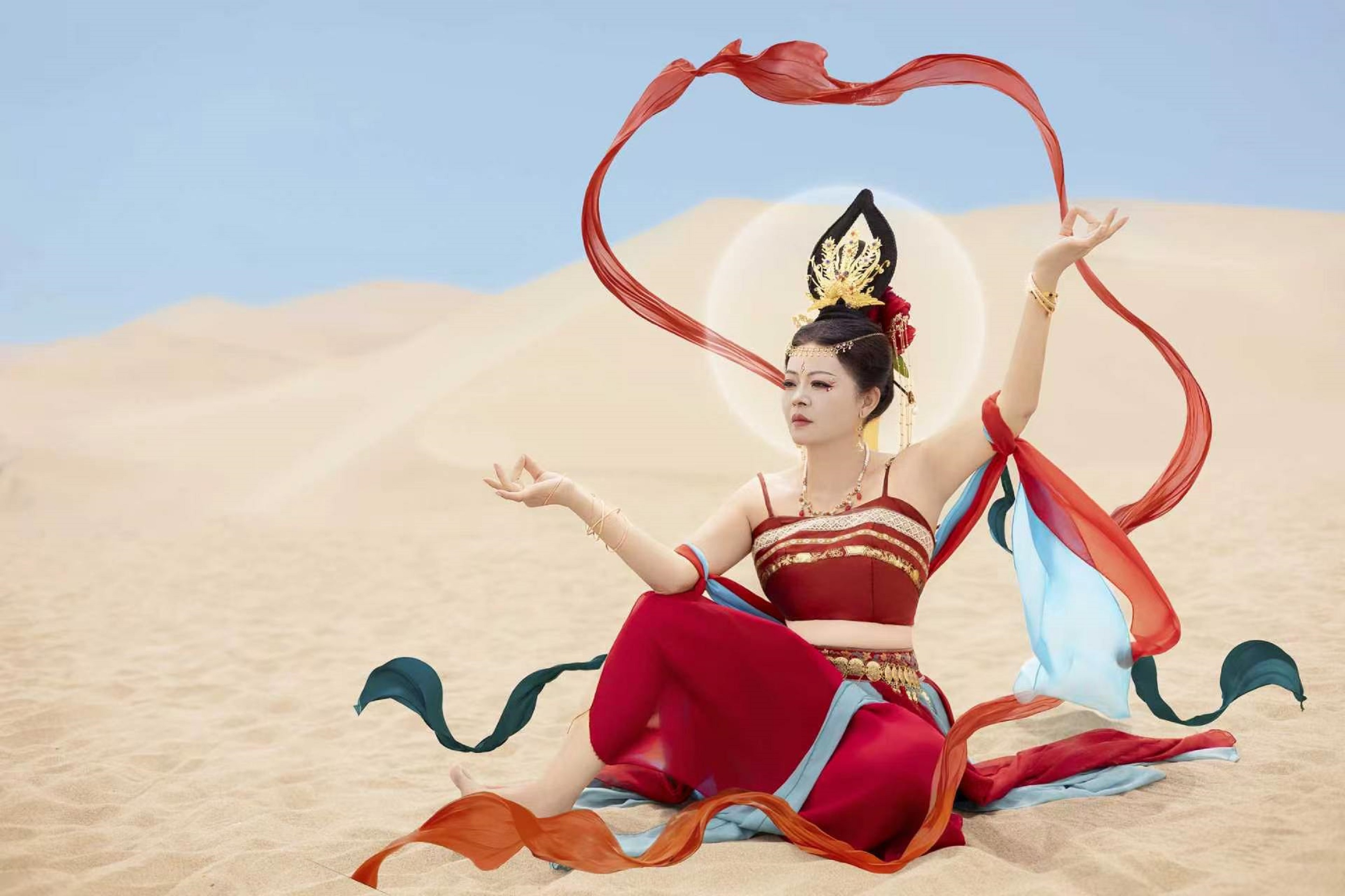 紅衣仕女靜坐沙海,神情安然靜謐從容 紅衣仕女靜坐沙海,神情安然靜謐從容