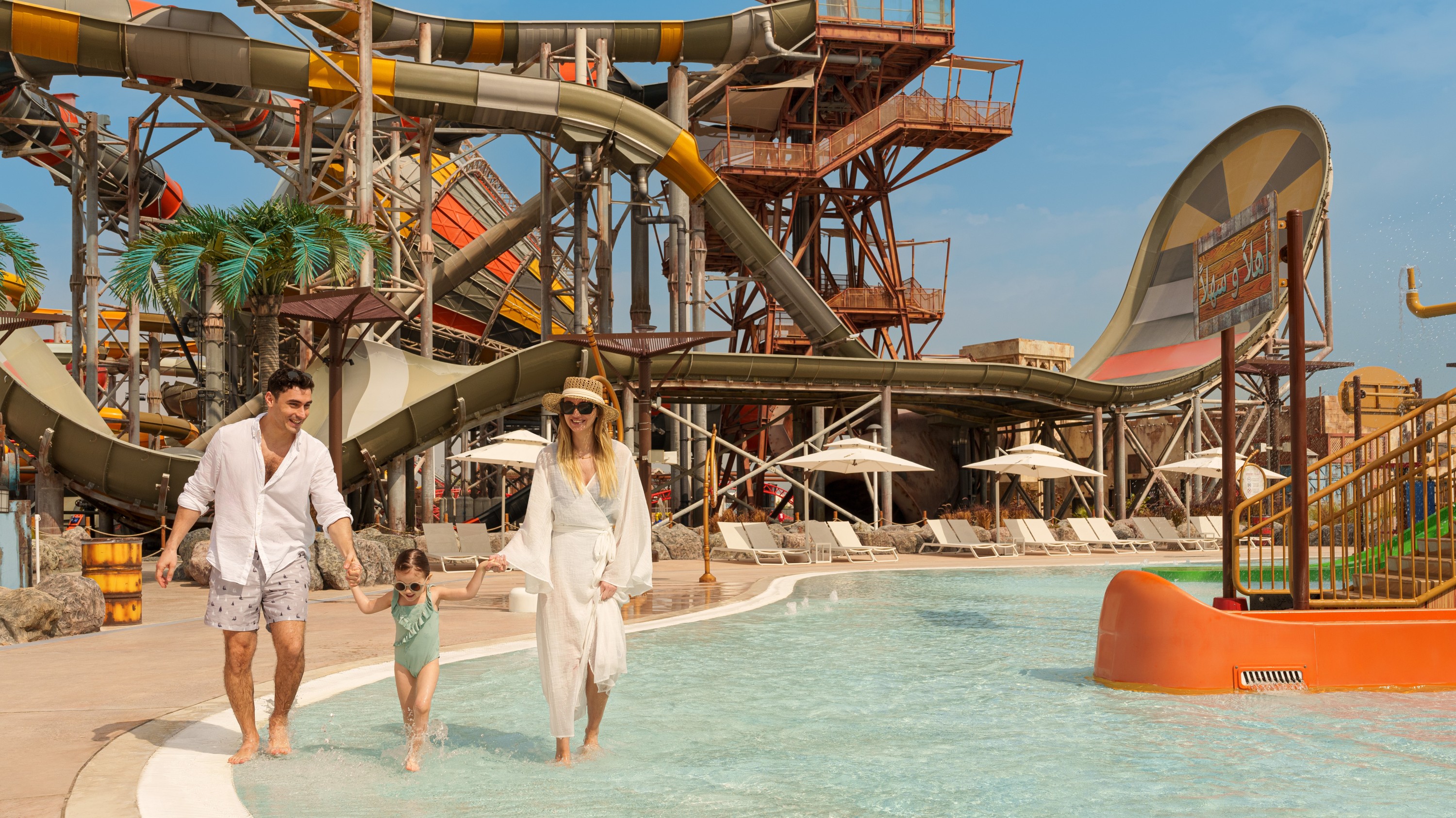 Family fun at Meryal Waterpark, strolling through shallow pools with thrilling slides all around