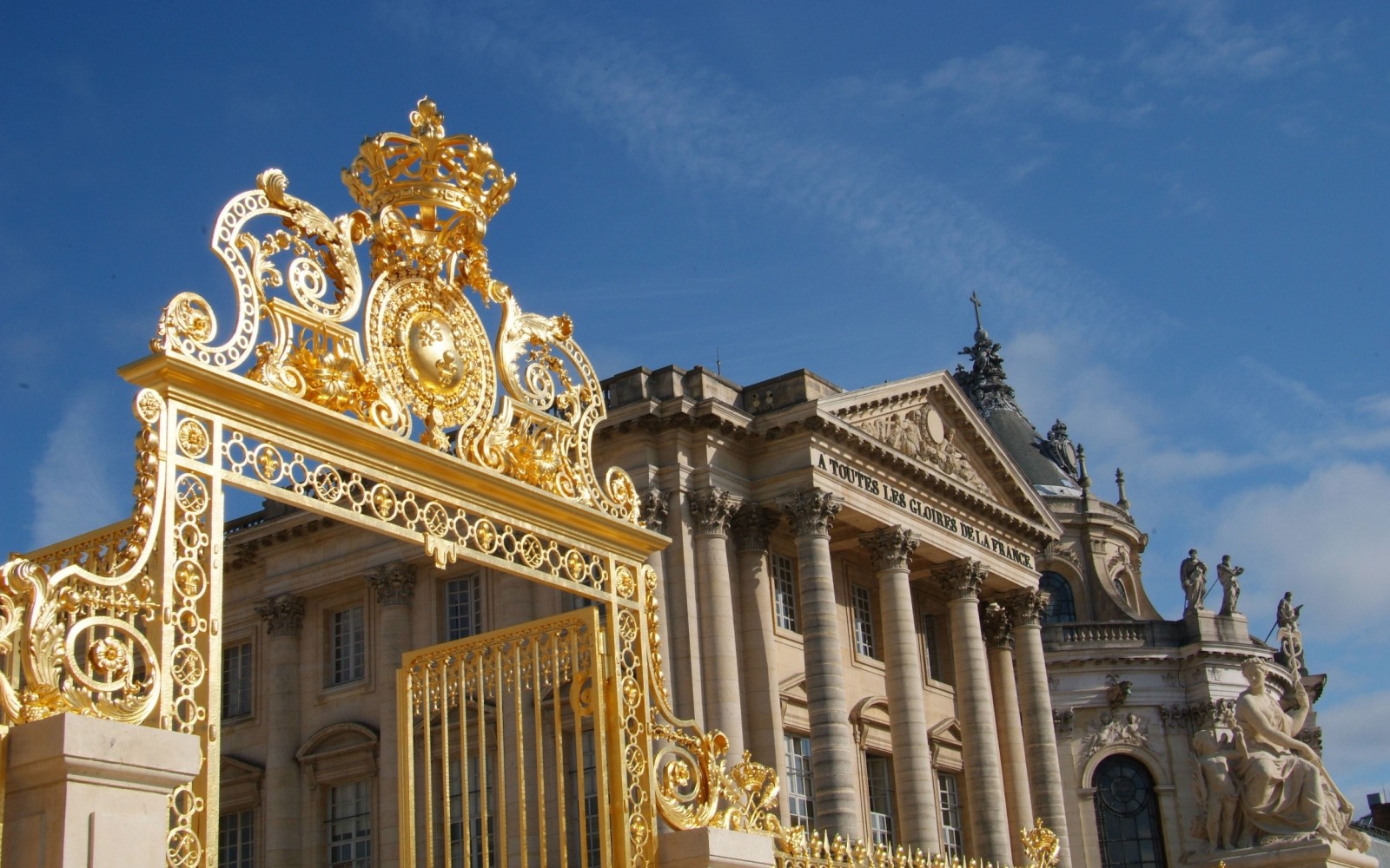 Majestic gates welcoming visitors to the Palace of Versailles entrance courtyard