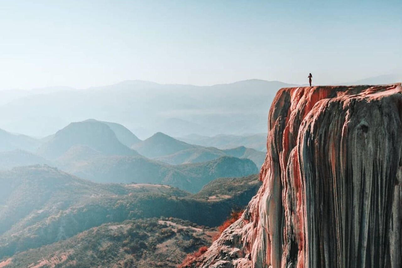 Traveler admiring the breathtaking landscape from a cliff at Hierve el Agua