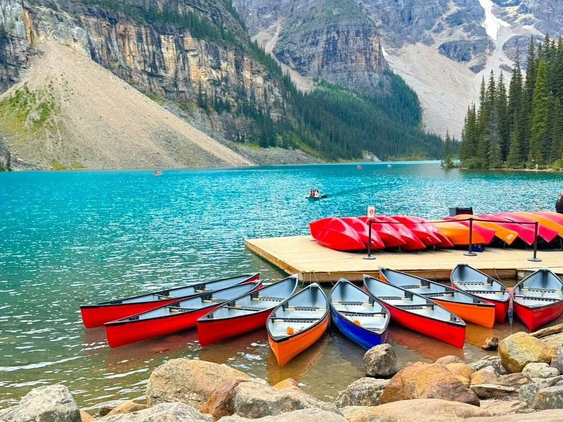 Crisp clear reflections of surrounding peaks mirrored perfectly on Moraine Lake.