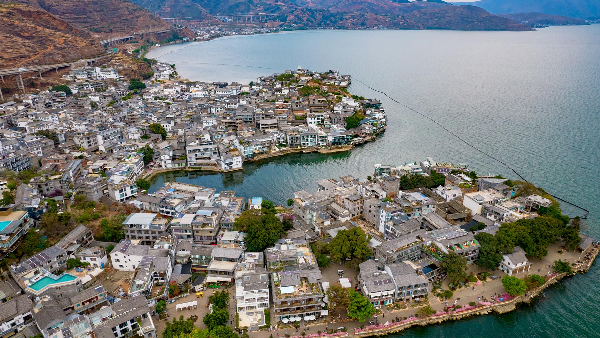Shuanglang Town is located by the sea and faces the Nanzhao Island. The town has a unique geographical location and extremely beautiful scenery. The sky is blue and the clouds are white. The lake is calm. There is a black-sailed boat on the water and red 