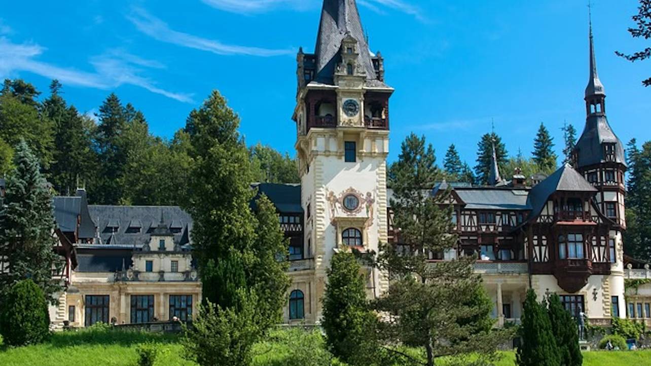Peles Castle's intricate German Neo-Renaissance architecture is surrounded by lush, scenic Carpathian Mountains
