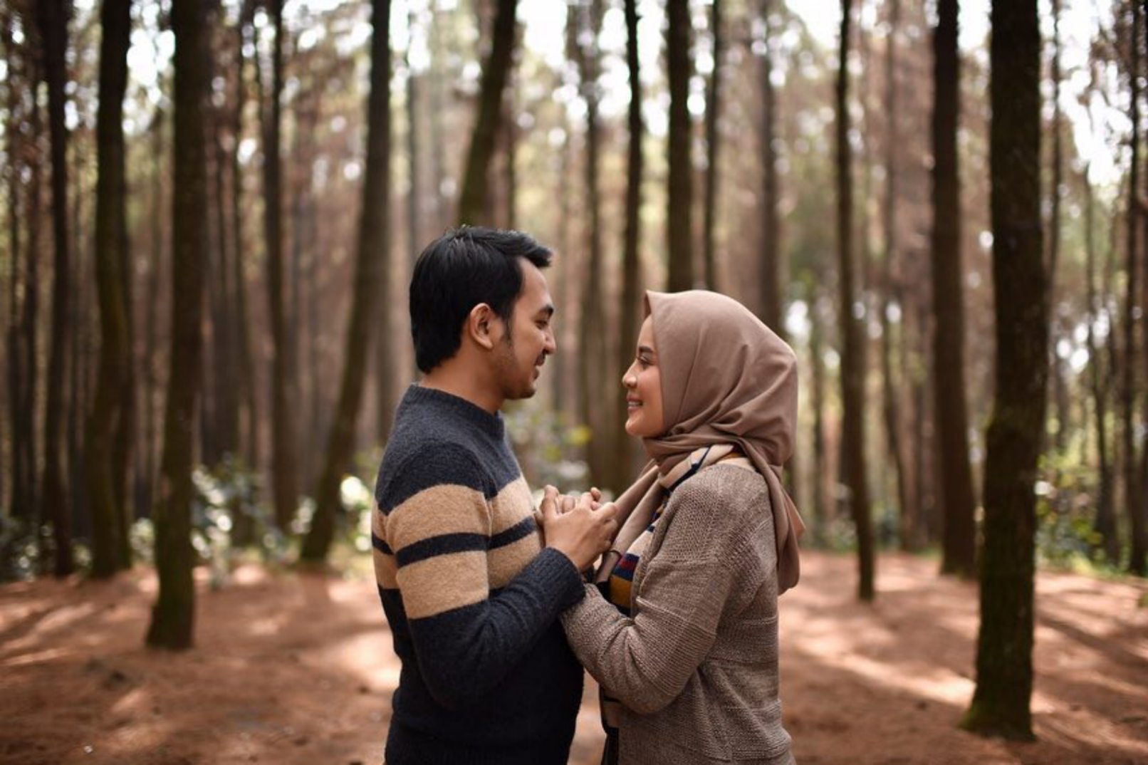 Man and woman holding hands in a forest