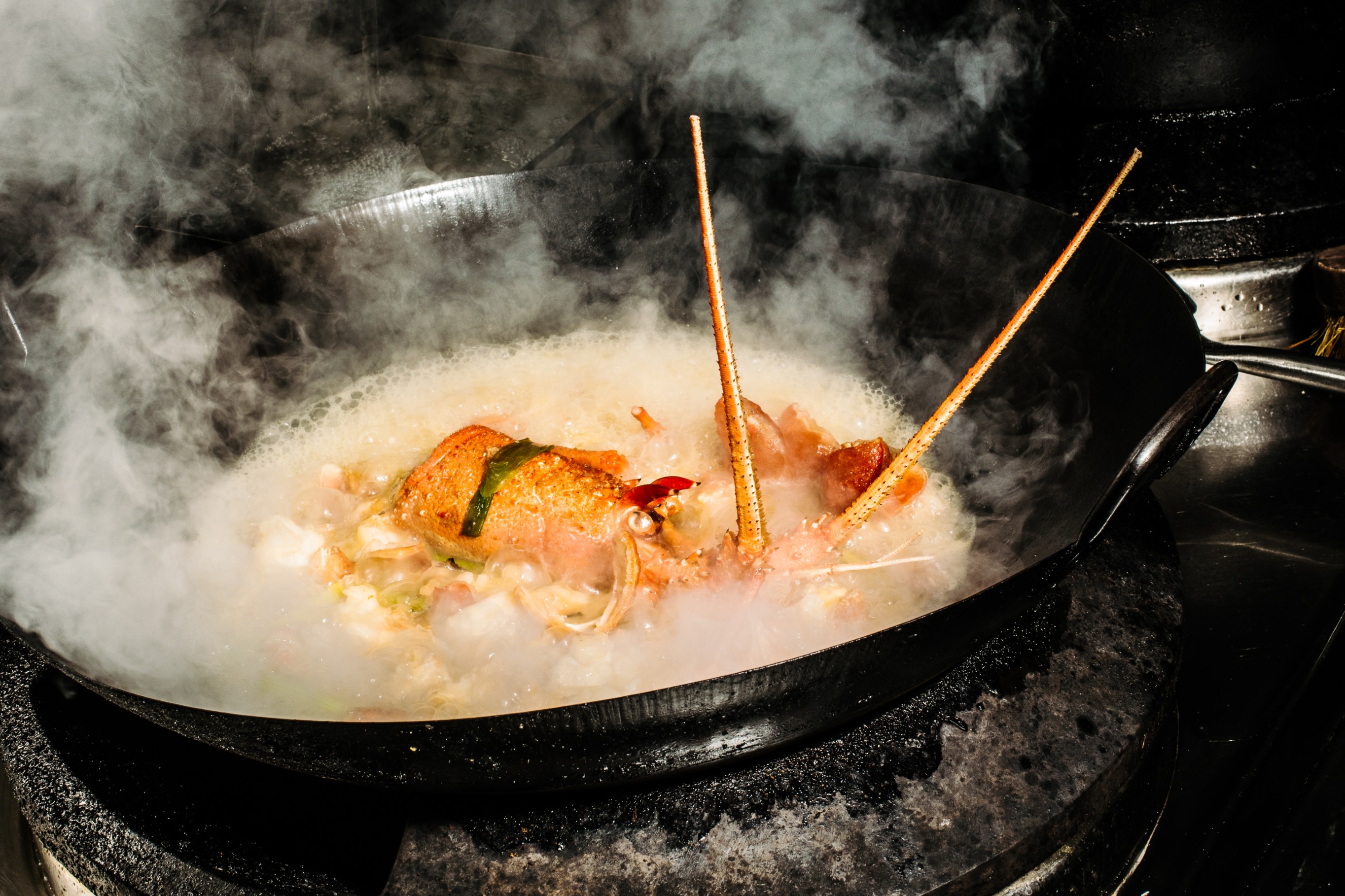 聞到濃郁的香氣，龍蝦菜餚在巨大的市場炒鍋中滋滋作響