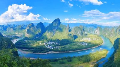 灕江在此繞出優美弧度，層疊峰林環抱田園村落，高空視角下，山水田園構成震撼的天然畫卷