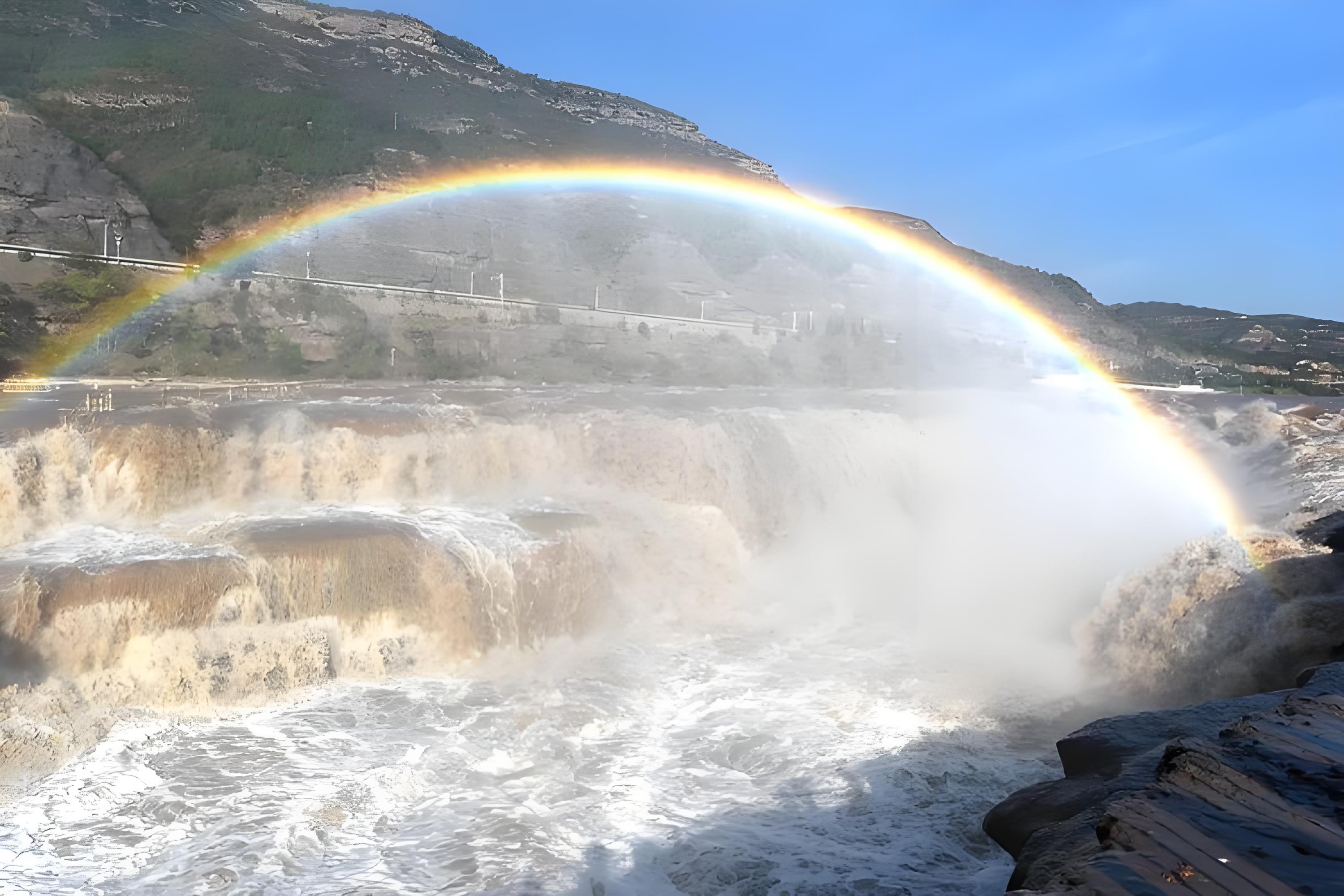 山西壺口瀑布飛瀑如雷、水霧蒸騰，在陽光的傾灑下，一道絢麗的彩虹橫跨洶湧的黃河之上，如夢似幻，與磅礴瀑布相映成輝。