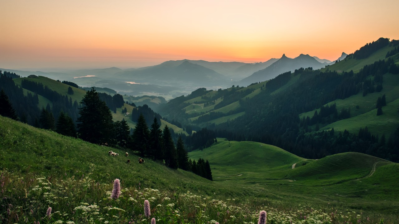 Experience the serene beauty of Gruyeres’ rolling hills and majestic alpine landscapes at sunset