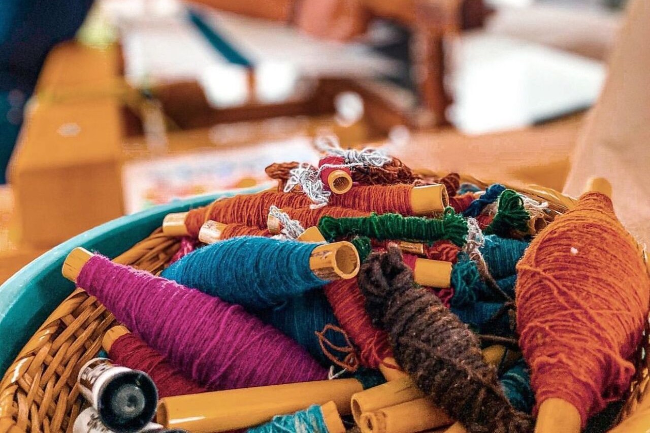 Close-up of hands dyeing wool with rich, natural colors from plants and insects
