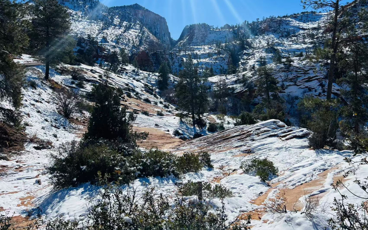 探索陽光灑落白雪皚皚山峰的靜謐冬日仙境