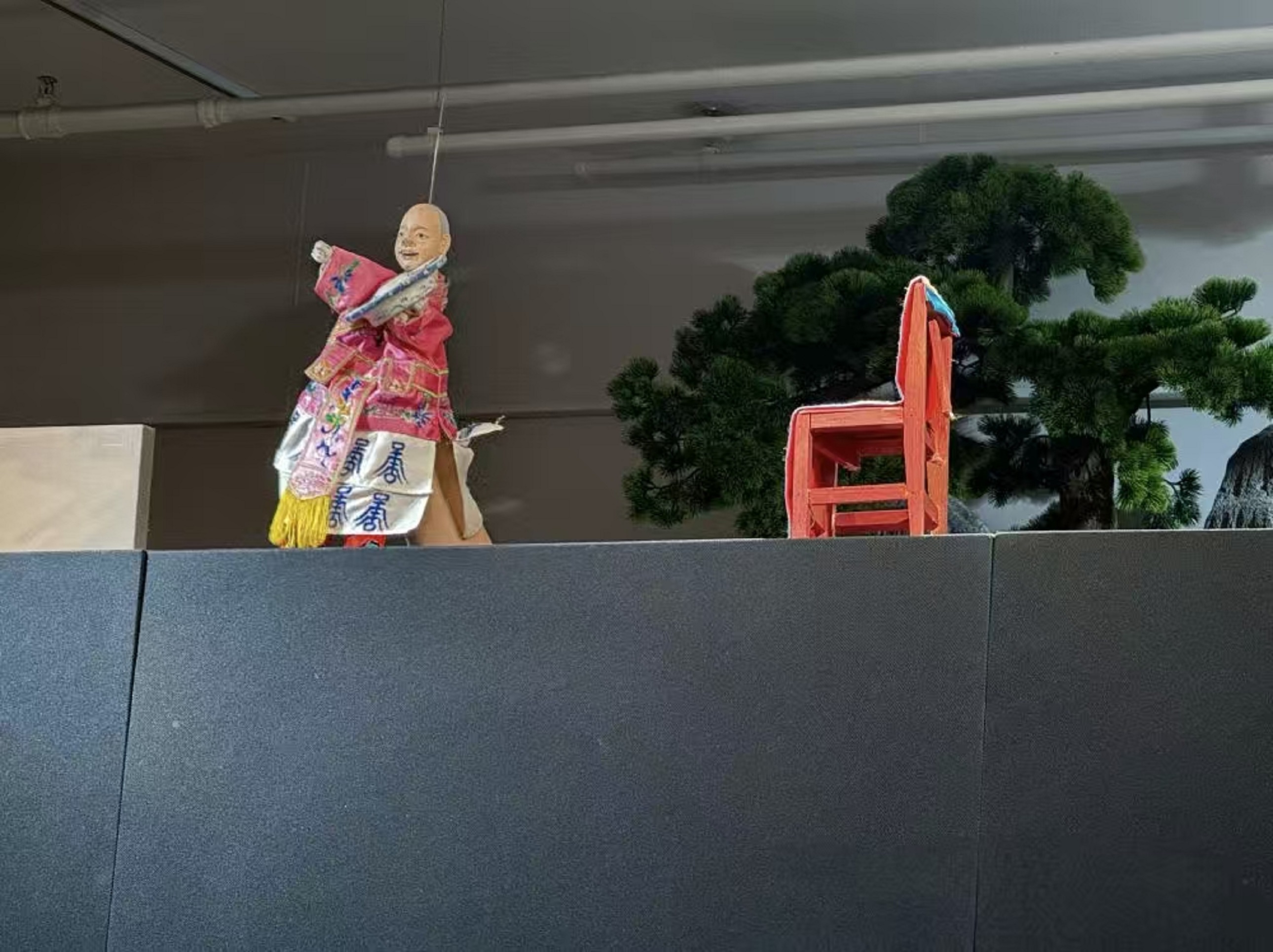 它踮著腳的模樣憨態可掬，像把春日的熱鬧，都揉進了這小小的木偶身段裡