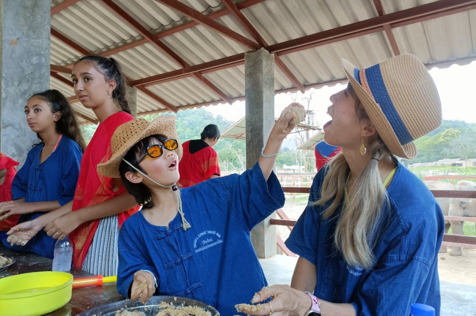 Visitors making healthy vitamin balls for elephants during an interactive elephant care activity in Chiang Mai.