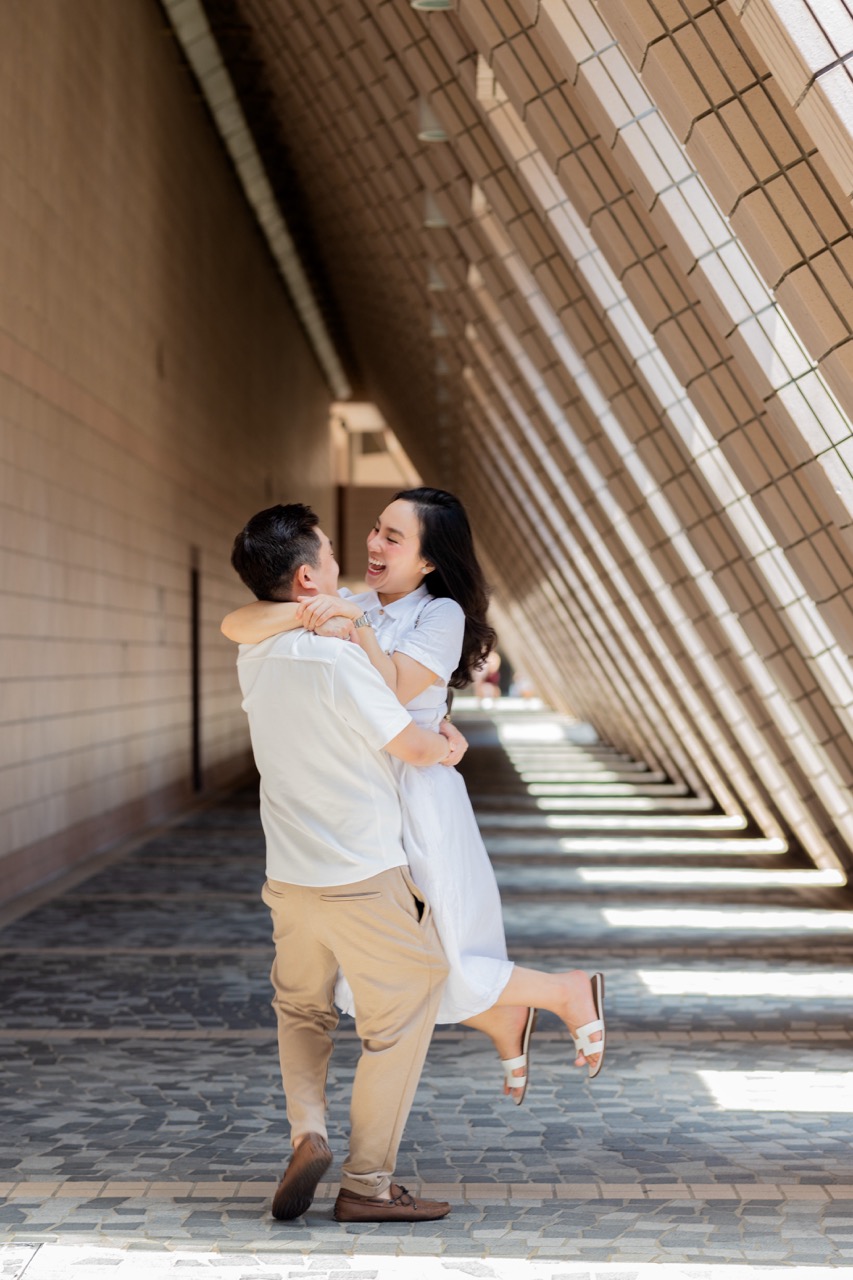 An intimate couple portrait set against the striking architectural beauty of the Hong Kong Cultural Centre, showcasing the city's rich arts scene.