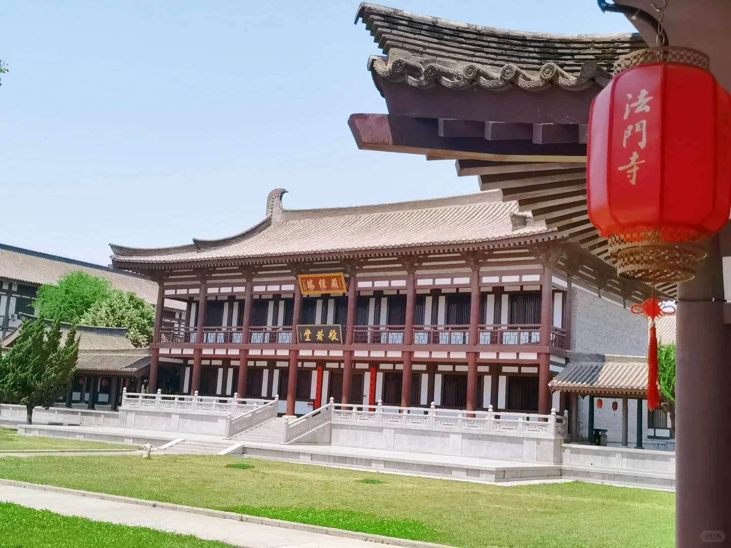 法門寺內古色古香的般若堂（藏經樓），紅柱白牆配飛簷斗拱，懸掛的 “法門寺” 紅燈籠盡顯唐風古韻