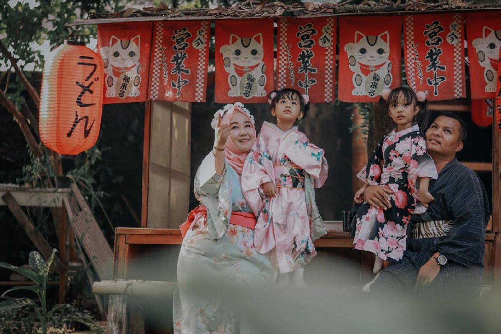 Family with children standing under Chinese lanterns