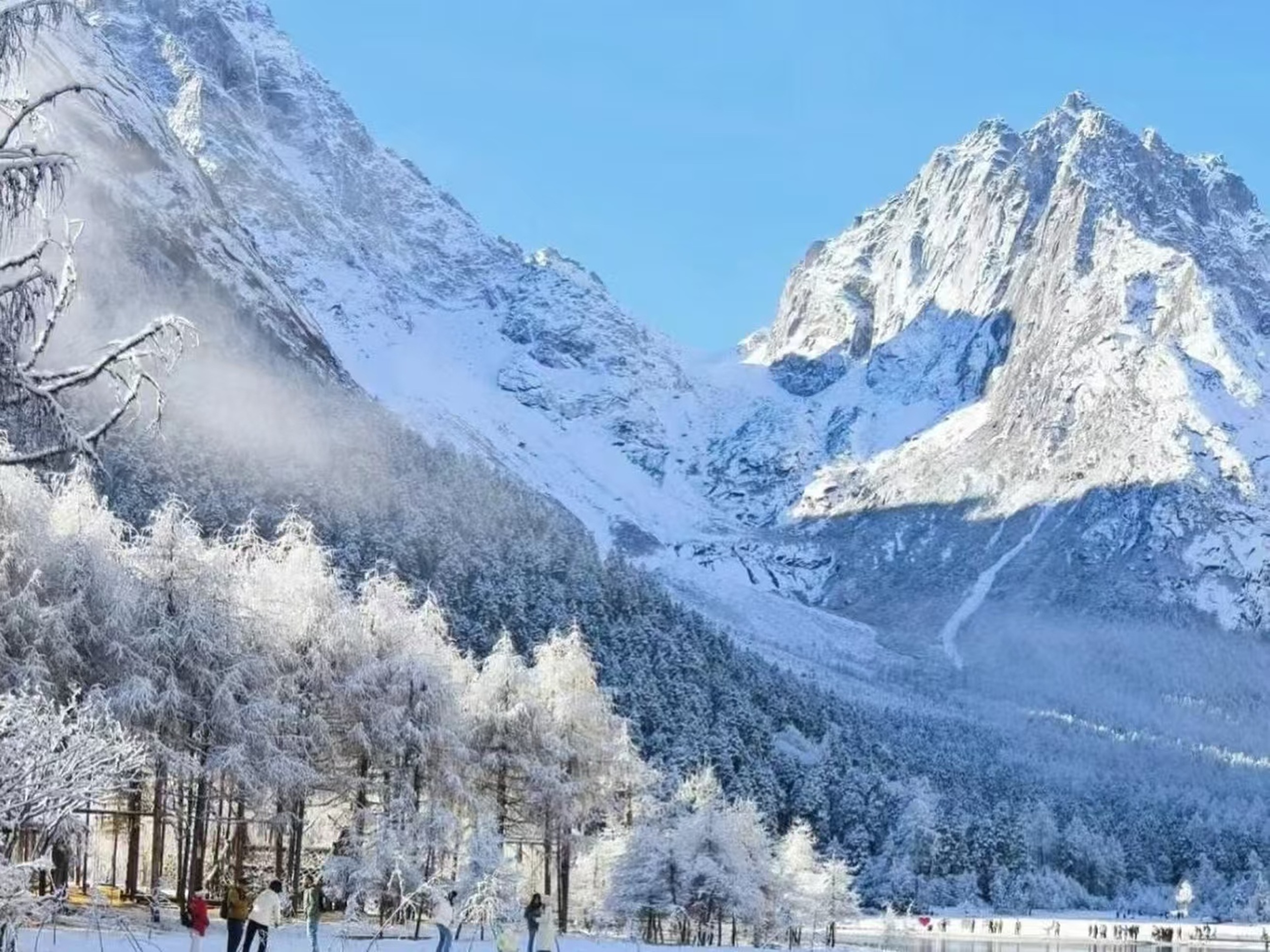 雪覆山巒與霧凇林相映,藍天襯得銀白世界愈發純淨,遊人穿梭其間,是冬日盛景裡的鮮活點綴 雪覆山巒與霧凇林相映,藍天襯得銀白世界愈發純淨,遊人穿梭其間,是冬日盛景裡的鮮活點綴